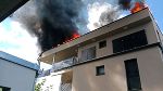 Dachstuhlbrand in einem Mehrparteienhaus in Wien-Favoriten, Rauch steigt auf.
